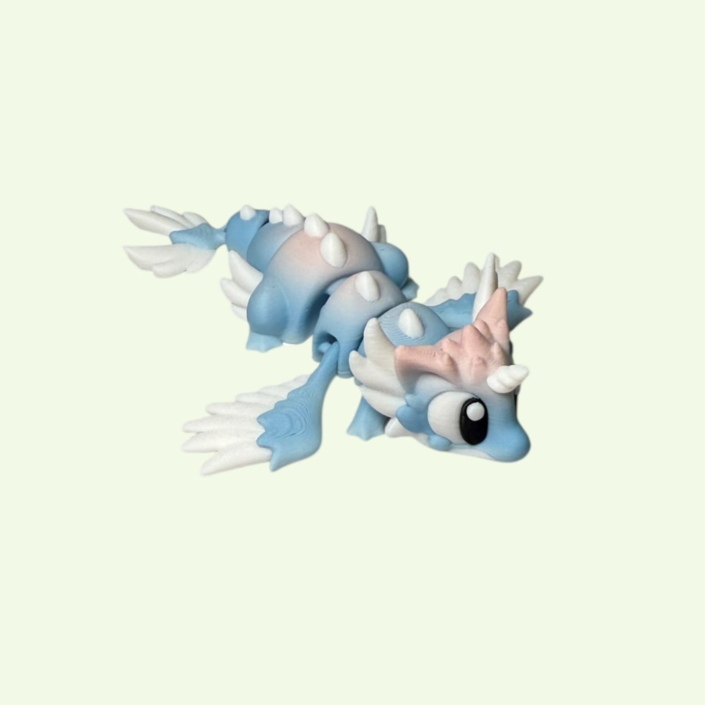 Toy figure of a blue and white creature on a light beige background
