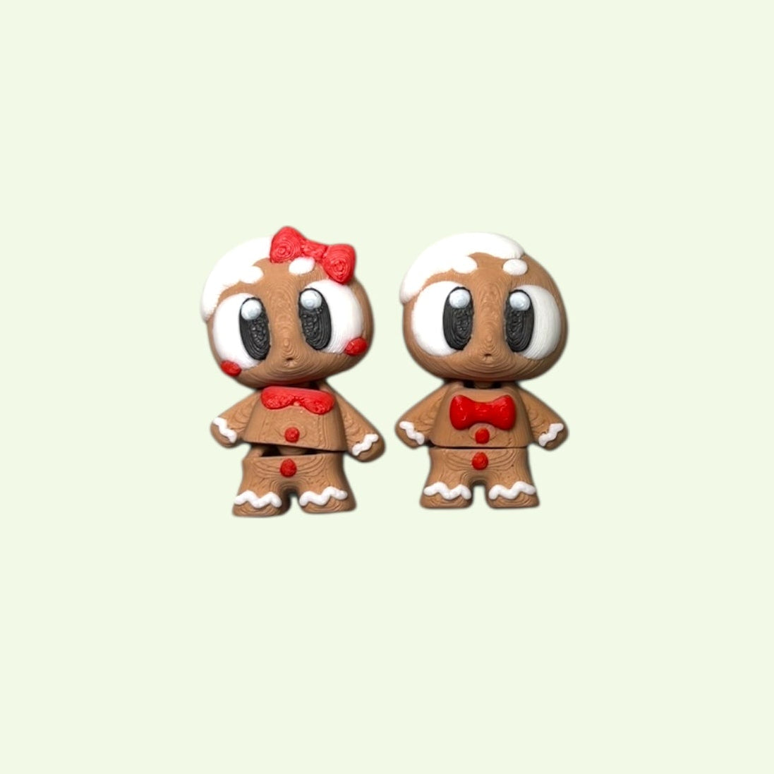 Two small gingerbread-themed figurines on a light beige background