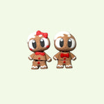 Two small gingerbread-themed figurines on a light beige background
