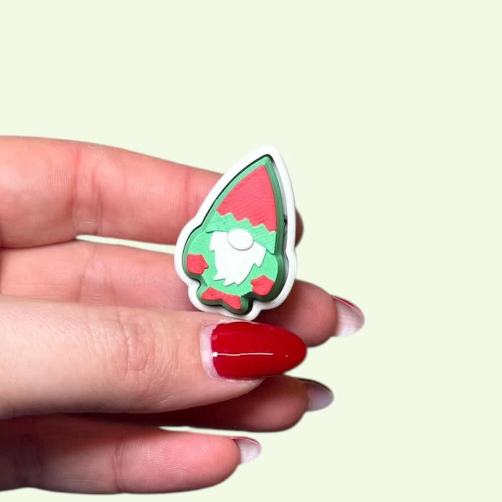 Hand holding a small colorful pin against a light background