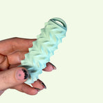 Hand holding a mint green Ridglets tactile fidget designed for sensory input and calming restless hands.