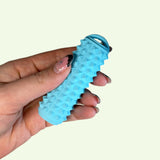 Close-up of a hand holding a blue Ridglets sensory fidget tool with textured surface.