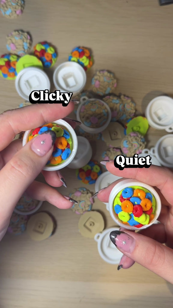 Colorful Cereal Clicker in hands, showcasing clickable bowl design with bright cereal pieces.